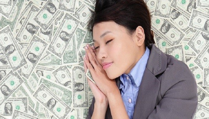 Young business woman sleeping on money bed and have a good dream, asian beauty model